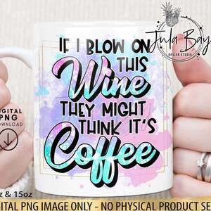 May include: White ceramic mug with the text "IF I BLOW ON THIS WINE THEY MIGHT THINK IT'S COFFEE" in a colorful design. The mug has a gold border and is held by a person. The mug is available in 11oz and 15oz sizes.