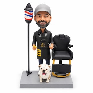 Peut inclure: Une figurine bobblehead personnalisée représentant un barbier barbu portant une casquette grise et un tablier noir, à côté d'un fauteuil de barbier et d'un poteau de barbier rouge, blanc et bleu. Un petit bouledogue blanc et marron est assis.