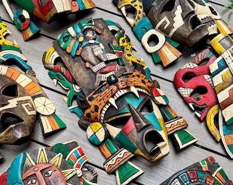 May include: A collection of intricately carved wooden masks, featuring vibrant colors and detailed designs. The masks depict various faces and figures, showcasing a range of hues including red, blue, green, and yellow. The masks are arranged on a wooden surface.