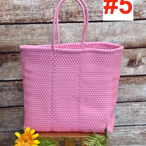 May include: A pink woven tote bag with two handles. The bag is rectangular and has a textured pattern. The number 5 is displayed in a white box with a red outline. The brand name "RAMPOS MX" is in the upper left corner.