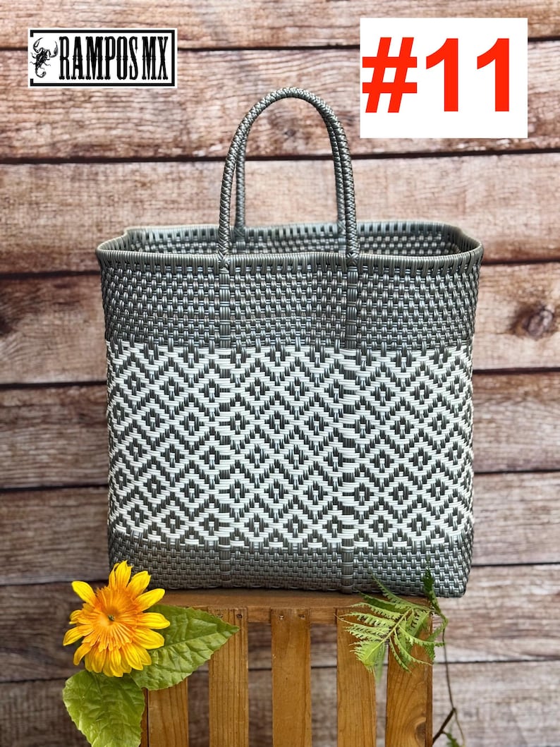 May include: A gray and white woven tote bag with a geometric pattern. The bag has a rectangular shape with a handle. The text "#11" is in the upper right corner. The brand name "RAMPOS MX" is in the upper left corner.