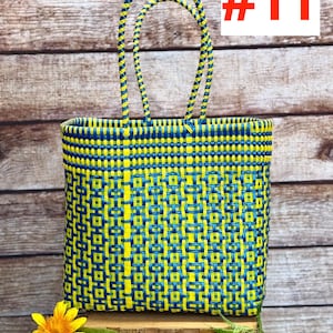 May include: A rectangular woven tote bag featuring a geometric pattern in bright yellow and dark blue plastic strips. The bag has two matching braided handles and displays the text RAMPOS MX and the number #11 in the upper corners.