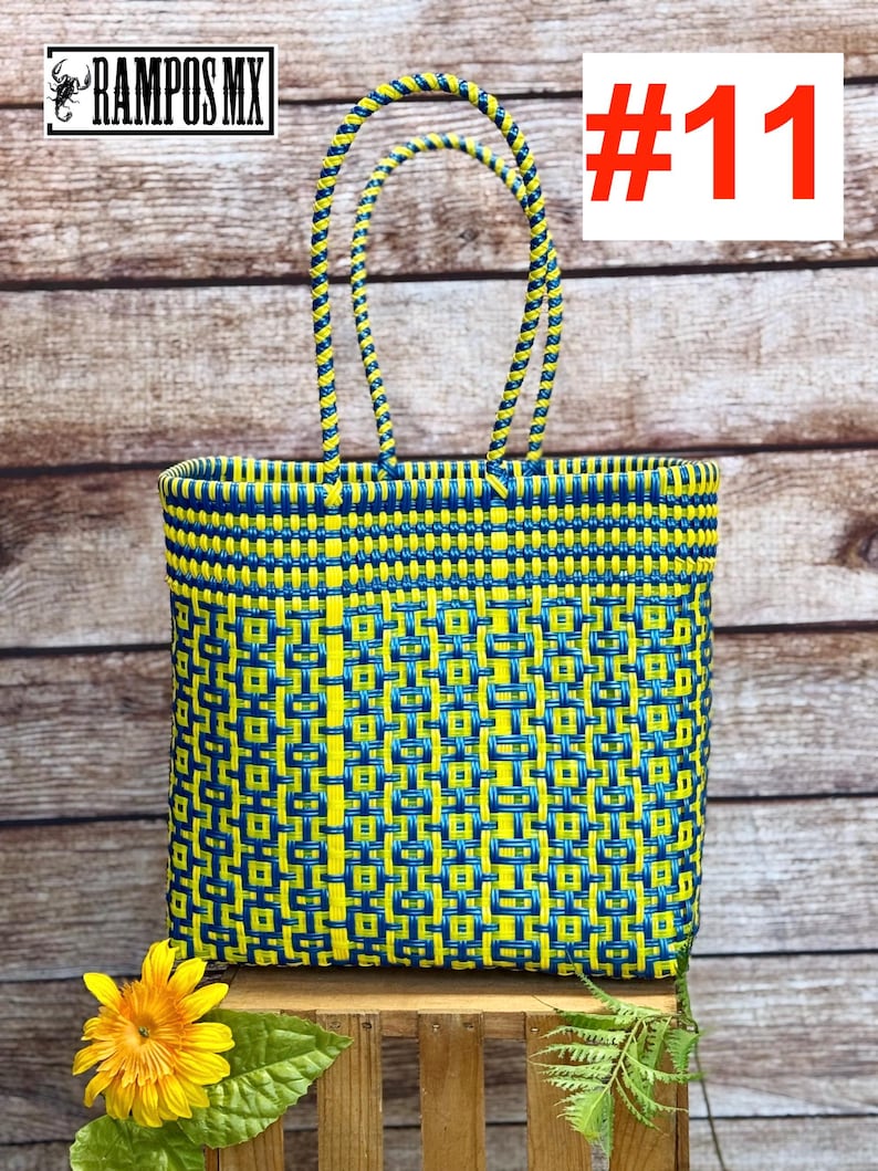 May include: A rectangular woven tote bag featuring a geometric pattern in bright yellow and dark blue plastic strips. The bag has two matching braided handles and displays the text RAMPOS MX and the number #11 in the upper corners.