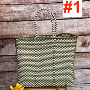 May include: A woven tote bag with a green and white checkered pattern. The bag has a rectangular shape with a sturdy handle. The handle is white and green. The bag is sitting on a wooden surface. The text "#1" is in the upper right corner.