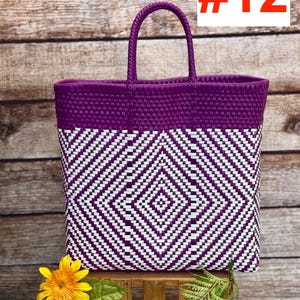 May include: A woven tote bag with a geometric diamond pattern in white and purple. The bag has a solid purple top and handle. The number 12 is displayed in red on a white background. The bag is sitting on a wooden surface.