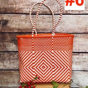 May include: A woven tote bag featuring a vibrant orange and white geometric diamond pattern. The bag has two braided white and orange handles. The text RAMPOS MX and a scorpion icon appear in the top left, with the number #6 in the top right.