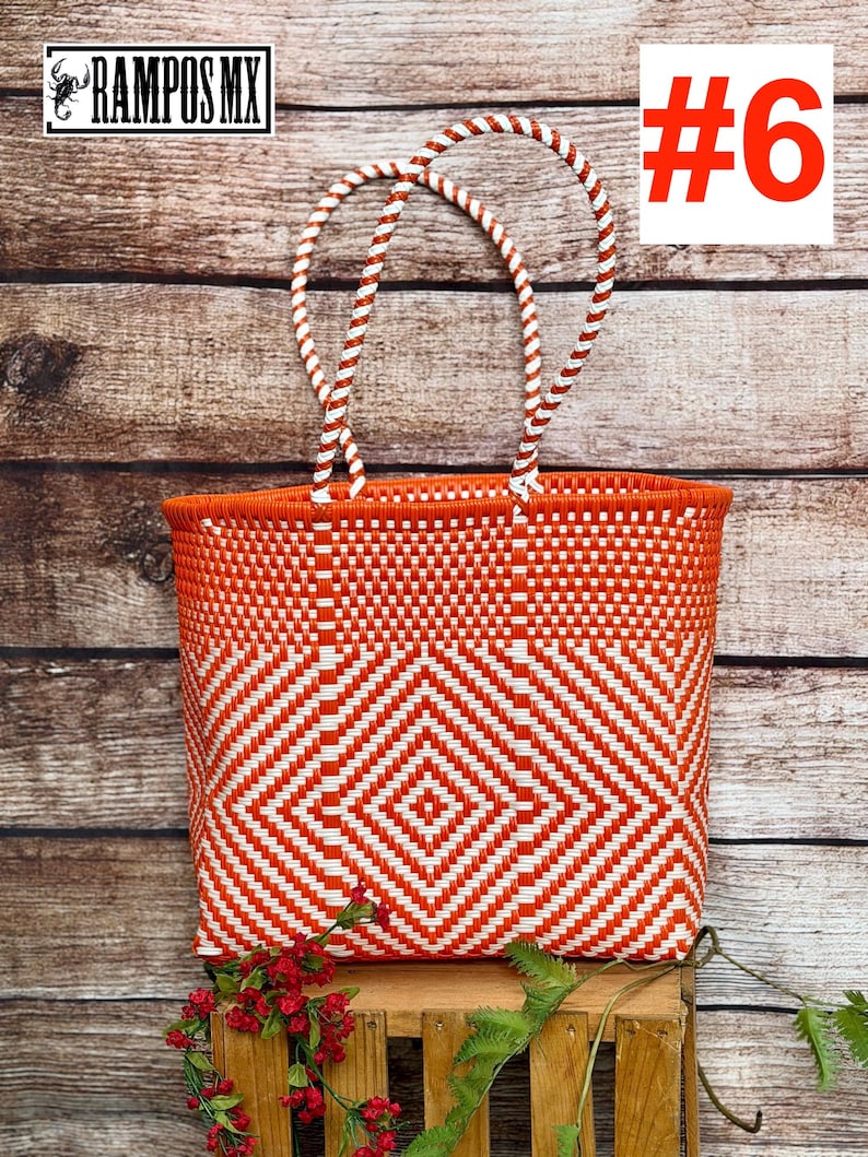 May include: A woven tote bag featuring a vibrant orange and white geometric diamond pattern. The bag has two braided white and orange handles. The text RAMPOS MX and a scorpion icon appear in the top left, with the number #6 in the top right.