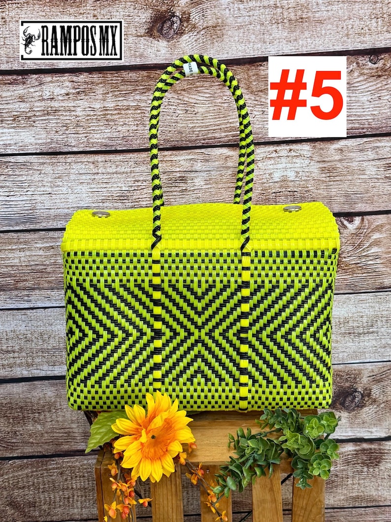 Op de afbeelding: Een rechthoekige gevlochten tas met een geometrisch ruitpatroon in neongeel en zwart. De tas heeft twee gevlochten neongele en zwarte handvatten en twee zilverkleurige metalen sluitingen aan de bovenrand. De tekst #5 is zichtbaar.