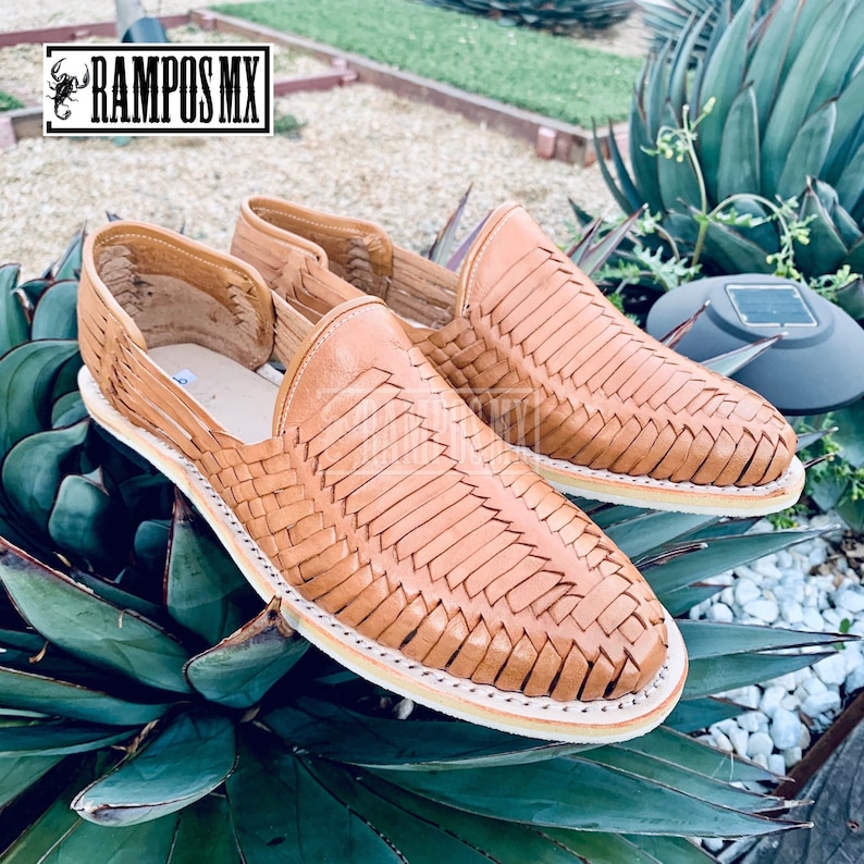 May include: A pair of tan leather sandals with a woven design. The sandals are made of a soft, supple leather and have a comfortable fit. haunches home tan. men leather tan clear color.