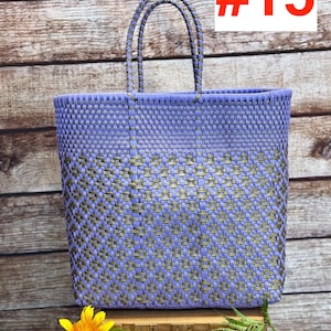 May include: A woven tote bag in lavender and gold tones, with sturdy handles. The bag is rectangular and features a textured pattern. The number "#15" is displayed in red. The brand name "RAMPOS MX" is visible in the top left corner.