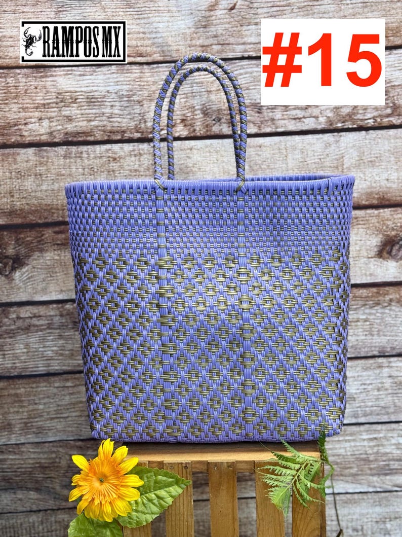 May include: A woven tote bag in lavender and gold tones, with sturdy handles. The bag is rectangular and features a textured pattern. The number "#15" is displayed in red. The brand name "RAMPOS MX" is visible in the top left corner.
