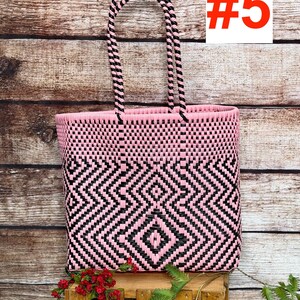 May include: A woven tote bag featuring a geometric diamond pattern in alternating pink and black plastic strips. The bag has two matching pink and black braided handles and displays the text RAMPOS MX and the number #5 in the upper corners.