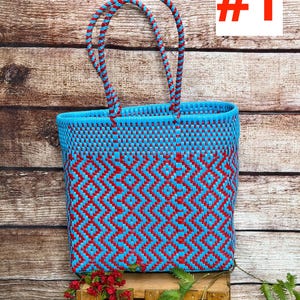 May include: A rectangular tote bag woven from bright blue and red plastic strips in a geometric diamond pattern. The bag features two matching braided blue and red handles attached to the top rim. The text RAMPOS MX and #1 are visible.