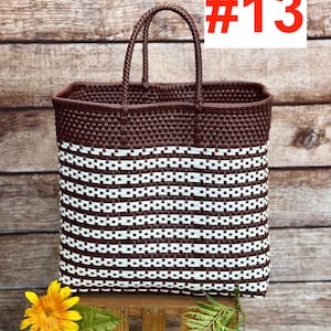 May include: A woven tote bag with a brown top and handles, and a white and brown striped body. The bag has the text "#13" in a red box. The logo "RAMPOS MX" is in the top left corner. A yellow flower and green leaves are in the foreground.
