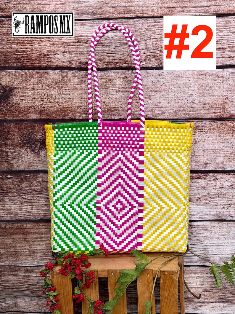 May include: A rectangular tote bag featuring a woven plastic pattern in bright green, hot pink, and yellow with white accents. The bag has two matching braided handles in pink and white. The text RAMPOS MX and a scorpion icon appear in the corner.