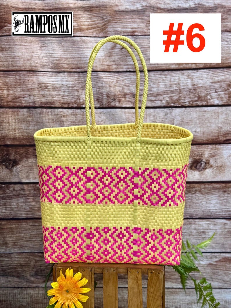 May include: A woven tote bag in yellow and pink. The bag features a geometric pattern in pink and yellow, with a rectangular shape and two handles. The number "#6" is displayed in red on a white background. The brand name "RAMPOS MX" is visible.