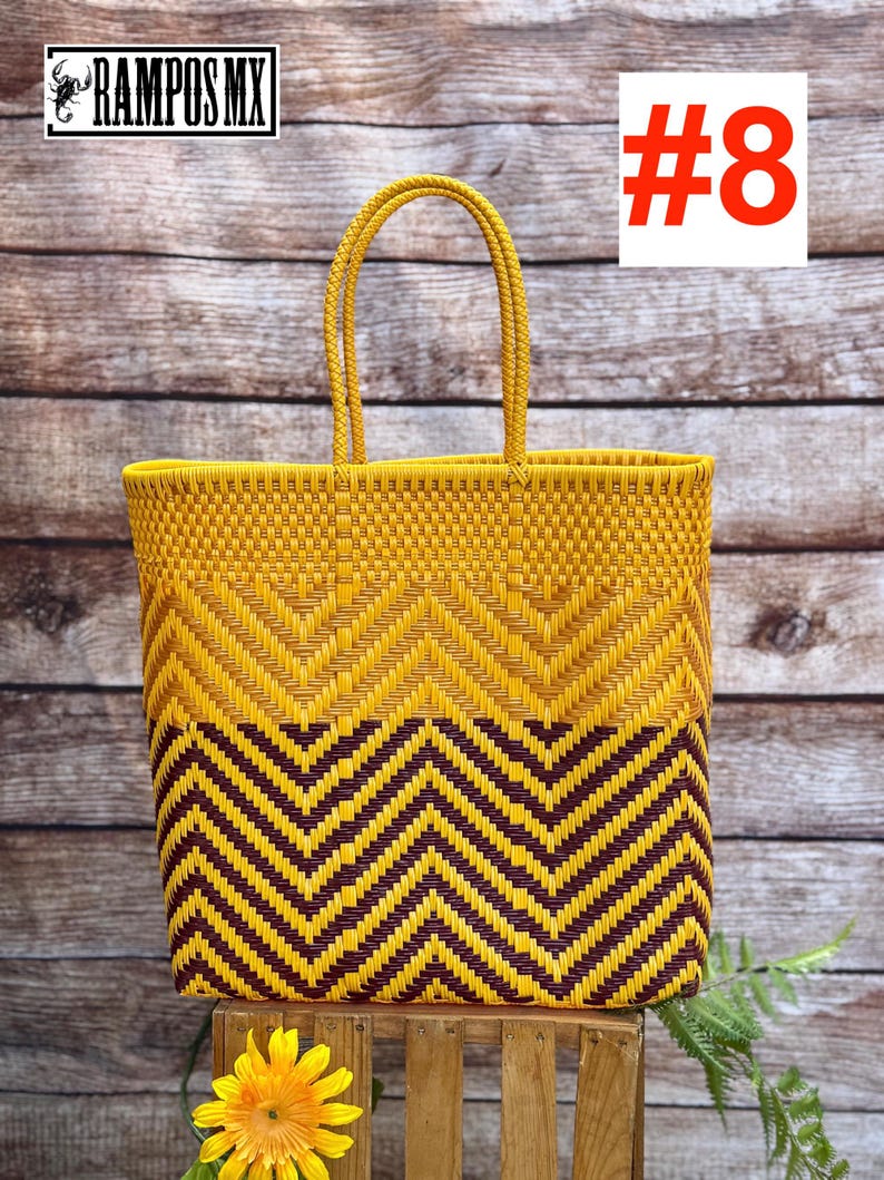 May include: A woven tote bag with a yellow and brown chevron pattern. The bag has two handles and a rectangular shape. The text "#8" is in a white box in the upper right corner. The brand name "RAMPOS MX" is in the upper left corner.