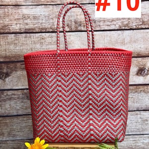 May include: Red and silver woven tote bag with a chevron pattern. The bag has two handles and the text "#10" in red. A yellow flower and green leaves are in the foreground. The brand name "RAMPOS MX" is in the top left corner.