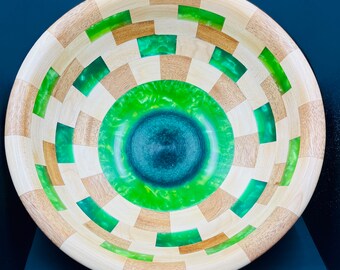 Maple and mahogany segmented bowl with some light and dark green resin segments in several rings as well as two of the bottom layers.