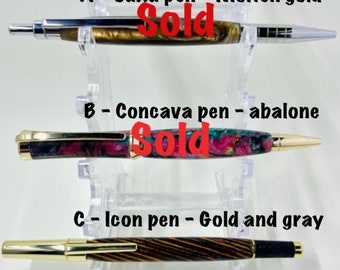 Handmade acrylic and wood turned pens – Saxa click pen molten gold acrylic, Concava twist pen abalone acrylic, and icon gold and gray wood