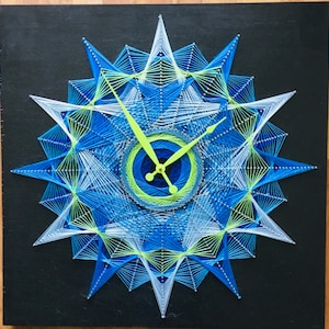 May include: A blue, white, and green string art clock with a geometric design. The clock hands are made of green string.