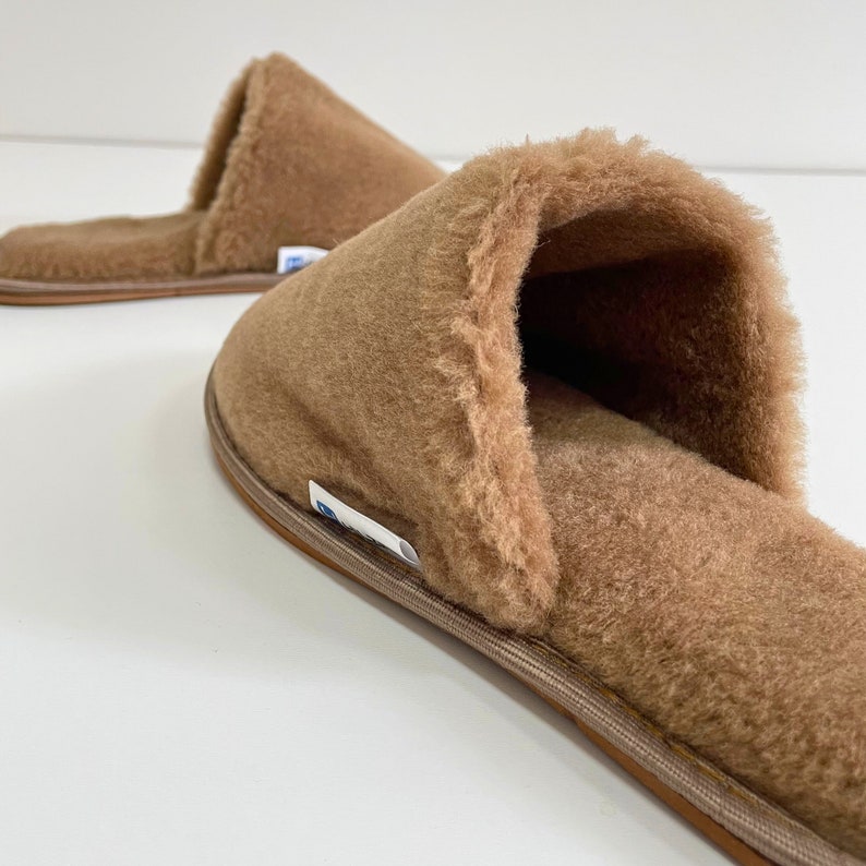 May include: A pair of brown fuzzy slippers with a soft, plush lining. The slippers have a simple design and are perfect for keeping your feet warm and cozy.