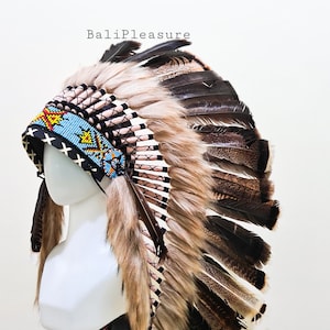 May include: A Native American headdress with a black, blue, and yellow beaded headband. The headdress features brown and black feathers, and tan fur trim. The text "BaliPleasure" is visible.