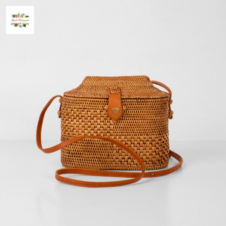 Peut inclure: Sac bandouli&egrave;re rectangulaire en rotin tress&eacute;, avec fermeture &agrave; rabat et bandouli&egrave;re en cuir marron. Le sac est de couleur beige naturel et pr&eacute;sente une surface textur&eacute;e. Fermoir en cuir marron.