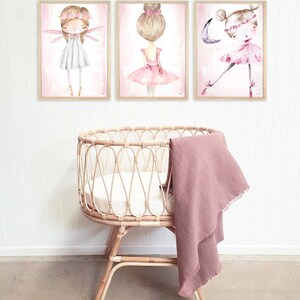 May include: Three framed watercolor illustrations of ballerinas with pink tutus and floral crowns. The illustrations are set against a light pink background.