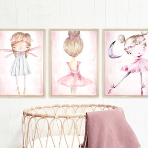 May include: Three framed watercolor paintings of ballerinas. The first ballerina is wearing a white dress and has wings. The second ballerina is wearing a pink tutu and has her hair in a bun. The third ballerina is wearing a pink tutu and is dancing with a crescent moon.