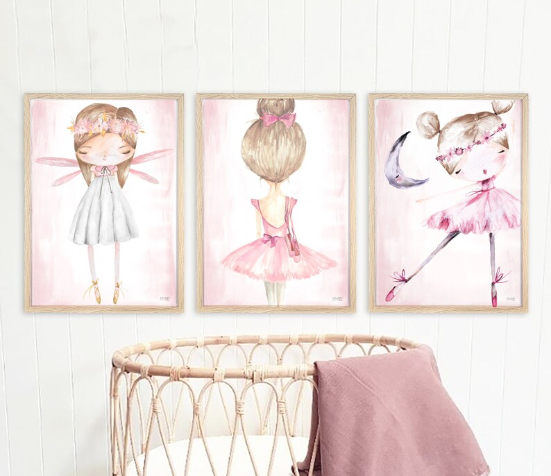 May include: Three framed watercolor paintings of ballerinas. The first ballerina is wearing a white dress and has wings. The second ballerina is wearing a pink tutu and has her hair in a bun. The third ballerina is wearing a pink tutu and is dancing with a crescent moon.