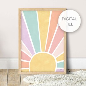 Op de afbeelding: Een digitale print van een kleurrijke regenboogzon met een gele zon in het midden. De kleuren zijn roze, oranje, geel, groen en paars. De print is ingelijst in een licht houten lijst.
