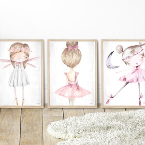 May include: Three watercolor paintings of ballerinas in pink and white dresses. The ballerina on the left has wings and a flower crown. The ballerina in the middle has a bun and a pink ribbon. The ballerina on the right is wearing a pink tutu and has a crescent moon behind her.