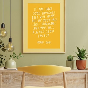 May include: A framed print with a yellow background and white text quoting Roald Dahl: "If you have good thoughts they will shine out of your face like sunbeams and you will always look lovely." The frame is yellow.