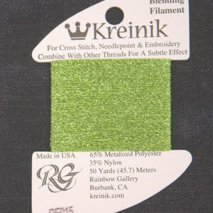 May include: A spool of bright green Kreinik blending filament for cross stitch and needlepoint. The label reads "For Cross Stitch, Needlepoint & Embroidery" and "Combine With Other Threads For A Subtle Effect". The spool contains 50 yards.
