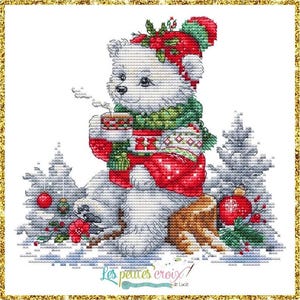 May include: Cross-stitch design of a white bear wearing a red and green winter hat and scarf, holding a steaming mug. The bear is seated in a snowy scene with Christmas trees and ornaments. The text "Les petites croix" is in the lower right corner.