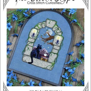 May include: Cross-stitch pattern titled "The Window" featuring a black cat, a house, and a full moon. The design is framed by a stone archway with lit candles and vines. The text "The Stitch Crypt" is at the top.