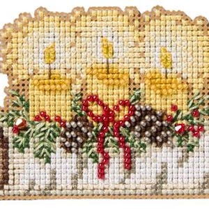 May include: A cross-stitch embroidery piece featuring three yellow candles with lit flames, accented by green pine needles, brown pinecones, and red beaded berries tied with a red beaded bow, all set against a white textured base.