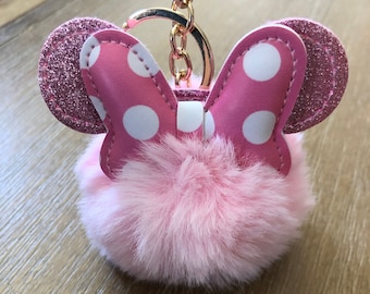 May include: Pink faux fur keychain with a pink and white polka dot bow and glitter ears.