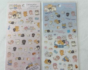 Puede incluir: Dos hojas de pegatinas con adorables gatos y perros de dibujos animados en varias poses. Las pegatinas están sobre un fondo rosa y azul con el texto "Corocoro coronya" y "Happiness Party of Sky Carriage and Kitten" impreso en ellas.