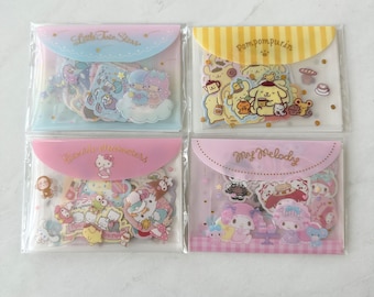 May include: Four clear plastic pouches with pink, yellow, and blue borders. Each pouch contains a set of colorful character stickers. The pouches are labeled "Little Twin Stars", "Pompompurin", "Hello Kitty Characters", and "My Melody".