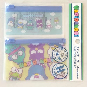 May include: Two clear plastic zippered pouches with colorful cartoon characters printed on them. The pouches are labeled "Hapidanbui" and are packaged together. The packaging includes the text "Fastener Case 2P" and "ファスナーケース(S・M各1枚入)".
