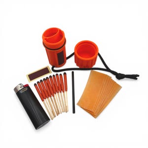 May include: An orange waterproof match container with a black lanyard, a black lighter, matches with red tips, and a striker pad. Also included are several orange fire starter sheets. The items are arranged on a white background.