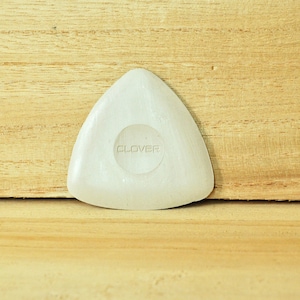 Puede incluir: Herramienta de costura triangular blanca con una hendidura redonda en el centro que dice "CLOVER" en mayúsculas.