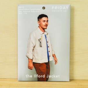 May include: A white paper pattern envelope with a photo of a person wearing a beige jacket, a blue shirt, and brown pants. The text on the envelope reads "#024 confident beginner for woven fabrics XS-7X FRIDAY pattern co. the Ilford Jacket"