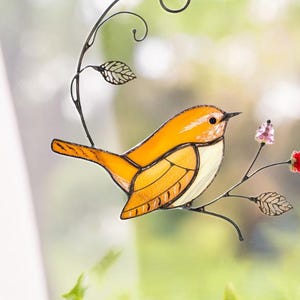 Carolina Wren stained glass suncatcher hanging in sunny window with ivy leaves, handmade bird decor with floral accents.