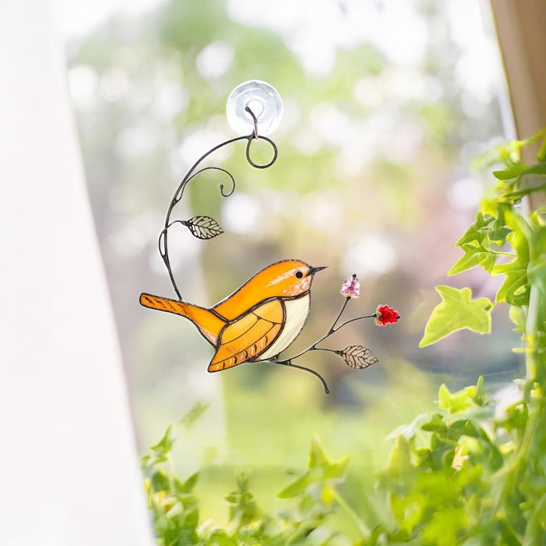 Carolina Wren stained glass suncatcher hanging in sunny window with ivy leaves, handmade bird decor with floral accents.