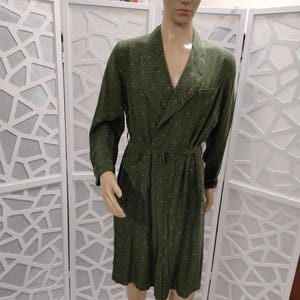 May include: A green robe with a small floral pattern. The robe has a shawl collar, long sleeves, and a tie belt.