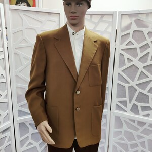 May include: A brown blazer with a single breasted closure and two patch pockets. The blazer has gold buttons.