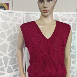 May include: A burgundy knitted sleeveless sweater vest with a V-neck.